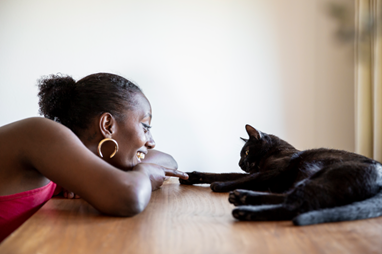 kat met vrouw op tafel